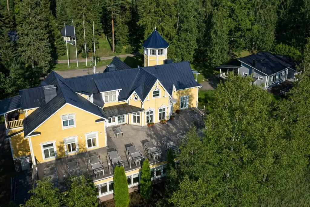 Keltainen todella iso kartanorakennus luonnon keskellä